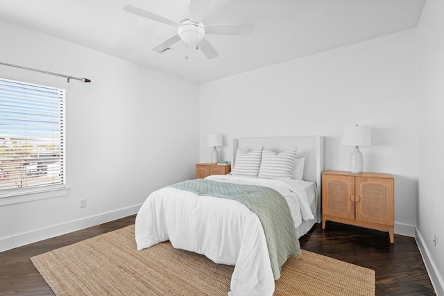 bedroom featuring ceiling fan, dark wood-type flooring, and multiple windows