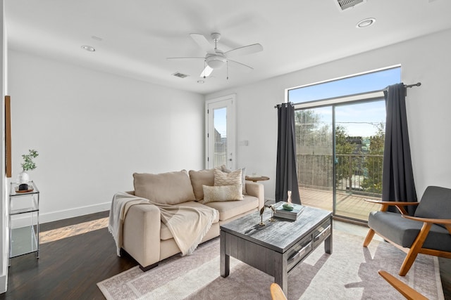 living room with ceiling fan and dark hardwood / wood-style flooring