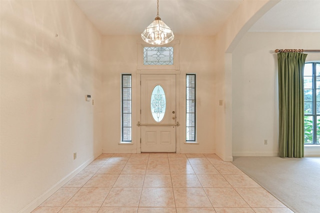 foyer entrance featuring a chandelier and light colored carpet