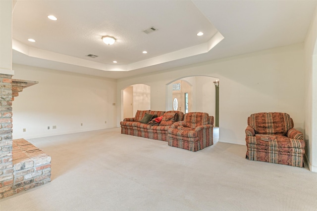 living room featuring light carpet, french doors, and a tray ceiling