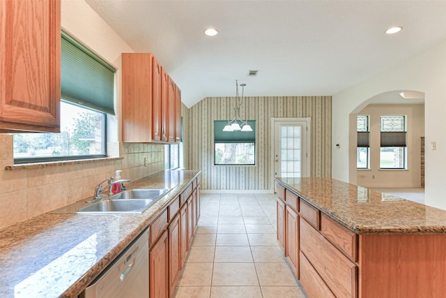 kitchen featuring dishwasher, a kitchen island, decorative light fixtures, sink, and light tile patterned floors