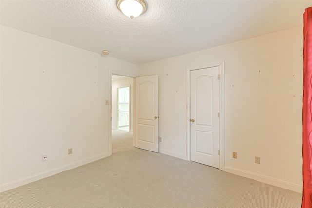 unfurnished bedroom featuring light colored carpet and a textured ceiling