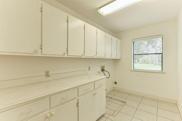 laundry room with light tile patterned floors, hookup for a washing machine, and cabinets