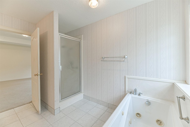 bathroom with a textured ceiling, independent shower and bath, and tile patterned floors