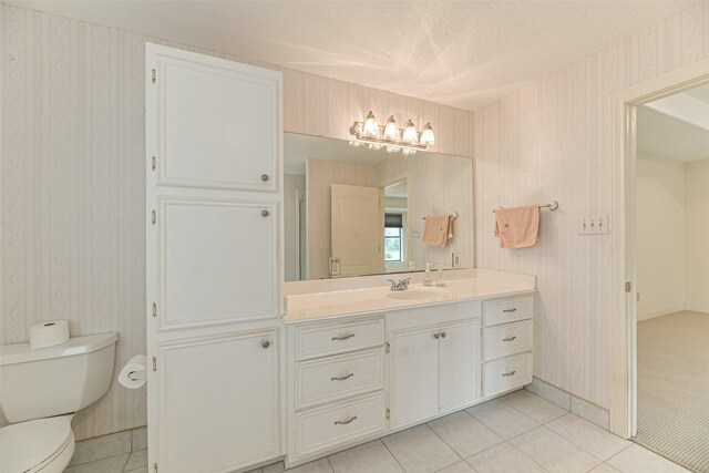 bathroom featuring toilet, vanity, and tile patterned flooring