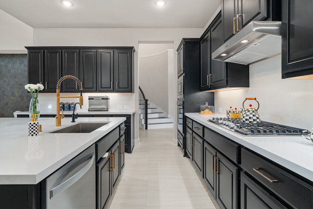 kitchen featuring sink, appliances with stainless steel finishes, and wall chimney range hood