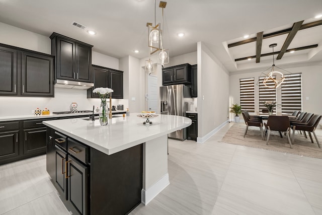 kitchen with stainless steel fridge with ice dispenser, coffered ceiling, a center island with sink, decorative light fixtures, and beam ceiling