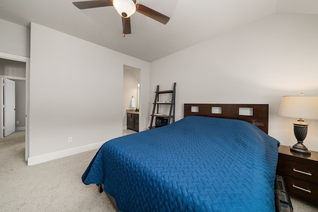 carpeted bedroom with ceiling fan, lofted ceiling, and ensuite bath