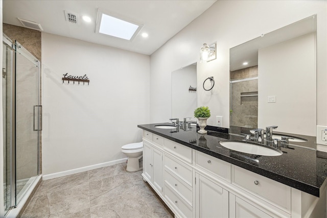 bathroom featuring toilet, a skylight, a shower with shower door, and vanity