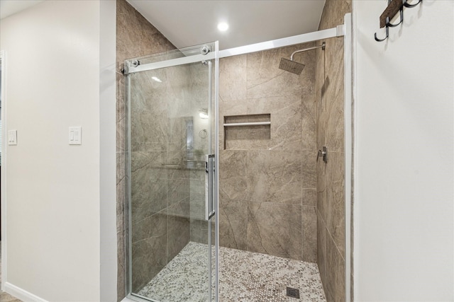 bathroom featuring a shower with shower door