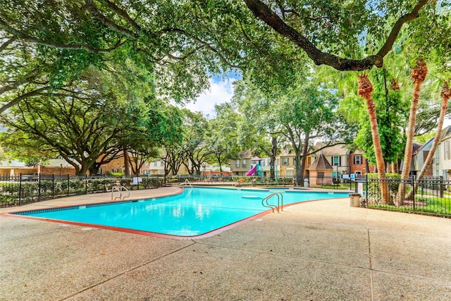 view of pool with a playground and a patio area