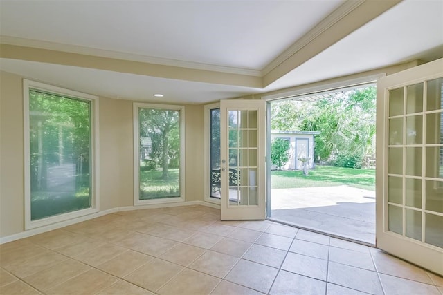 doorway with light tile patterned floors, ornamental molding, and french doors