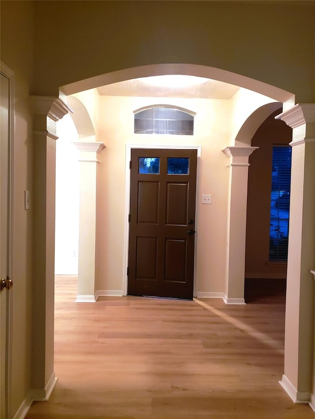 entryway featuring light hardwood / wood-style floors and decorative columns