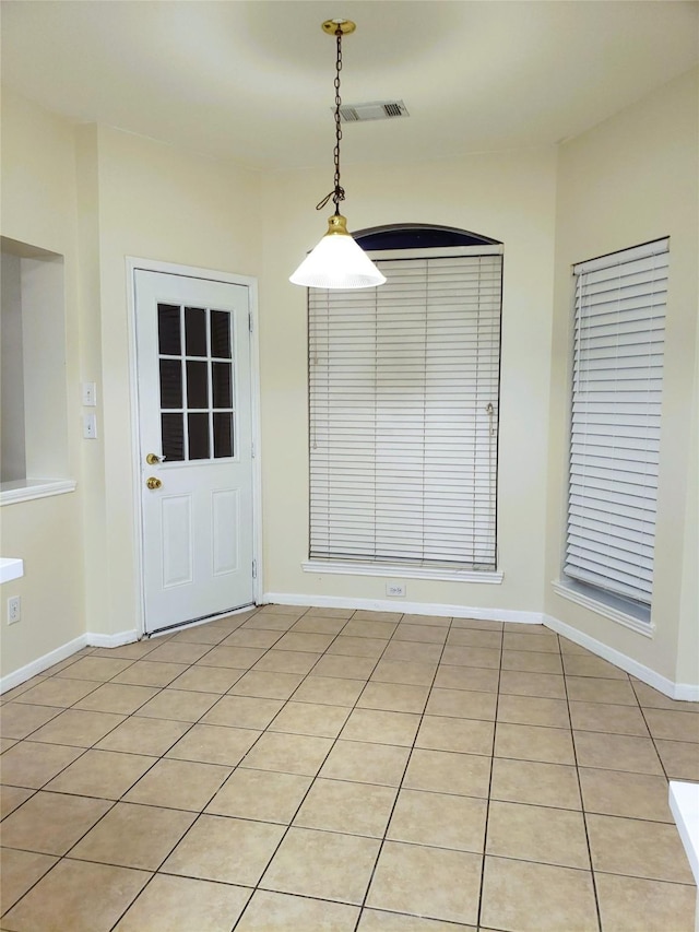 unfurnished dining area with light tile patterned flooring