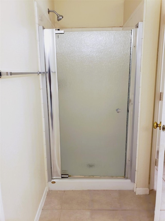 bathroom with a shower with shower door and tile patterned floors