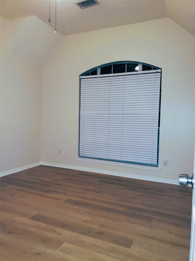 unfurnished room featuring lofted ceiling and hardwood / wood-style flooring