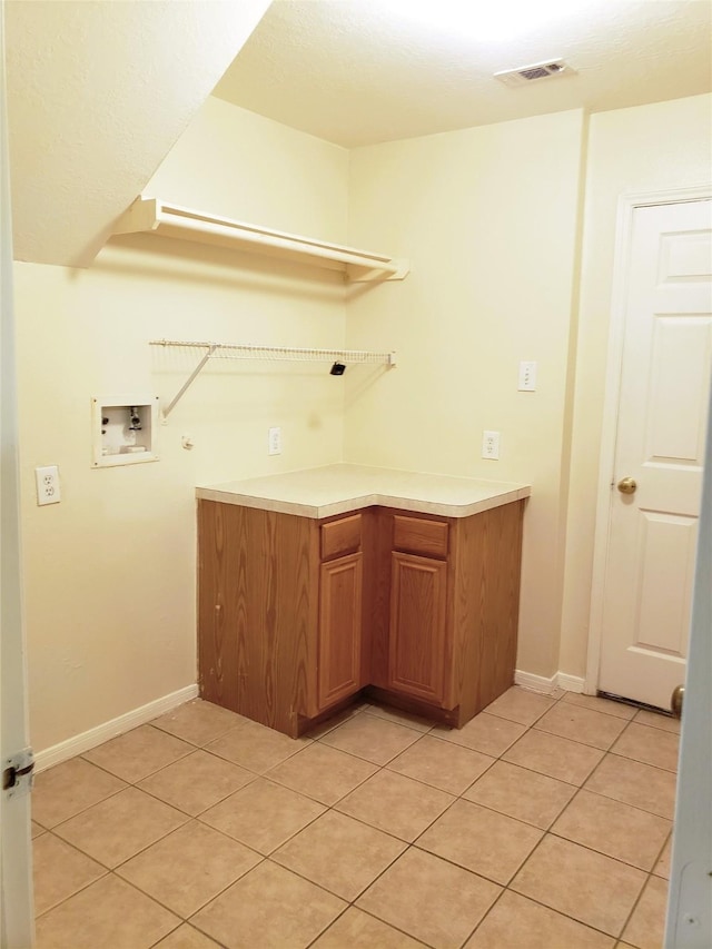 clothes washing area with cabinets, light tile patterned floors, and hookup for a washing machine