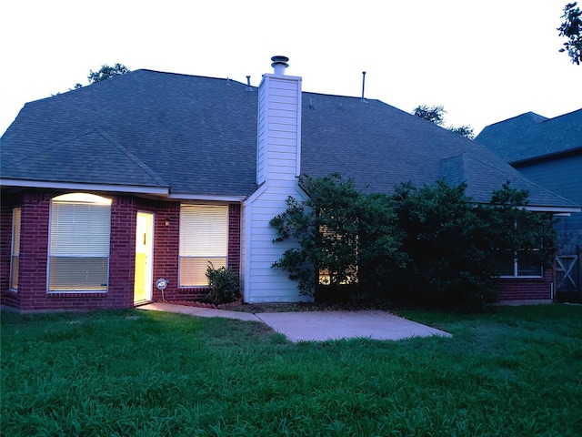 rear view of property with a patio and a yard