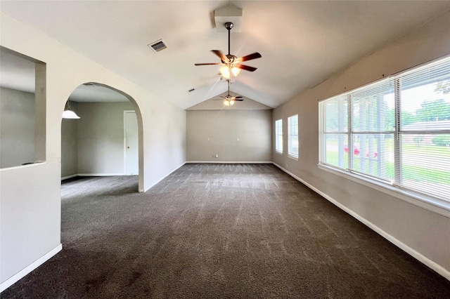 unfurnished room with ceiling fan, dark colored carpet, and lofted ceiling