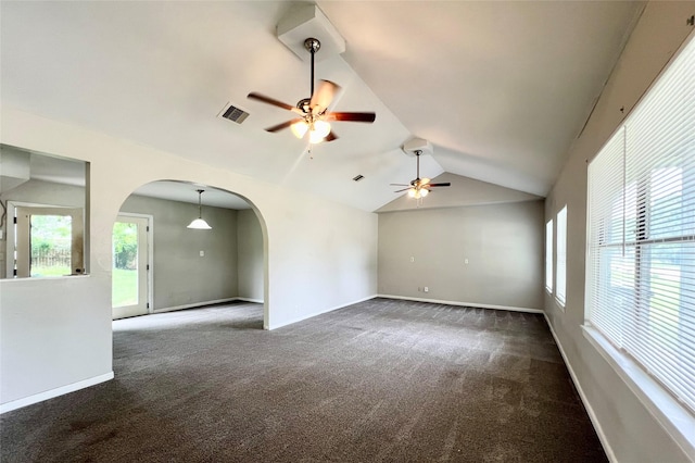 unfurnished living room with ceiling fan, dark colored carpet, and vaulted ceiling