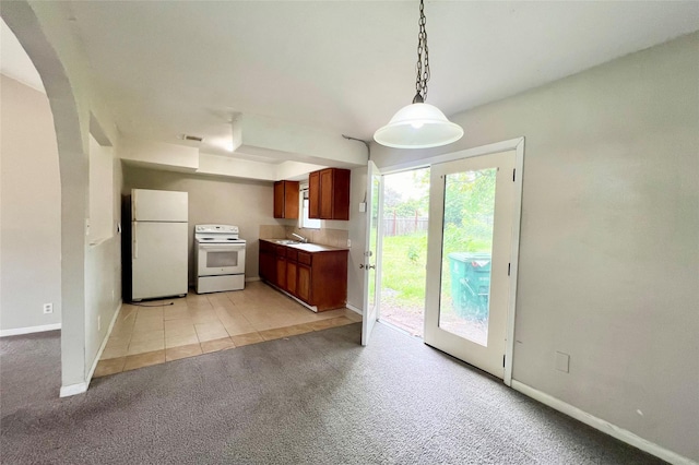 kitchen with light colored carpet, white appliances, sink, and hanging light fixtures