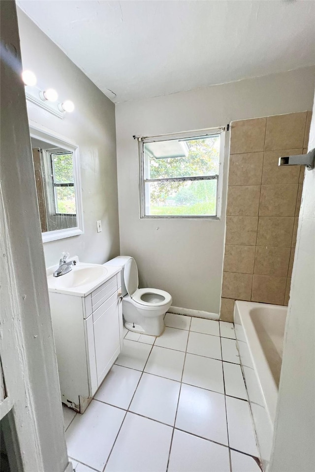 bathroom featuring tile patterned flooring, toilet, vanity, and a healthy amount of sunlight