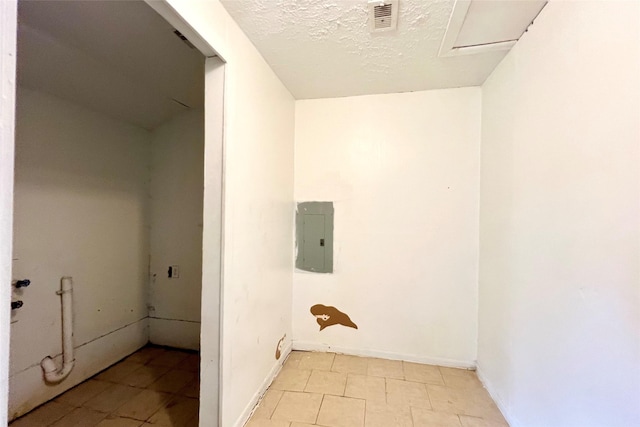 laundry room featuring a textured ceiling and electric panel