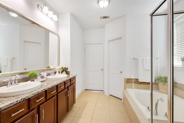 bathroom featuring vanity, tile patterned floors, and a relaxing tiled tub