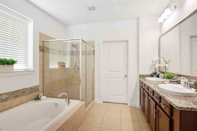 bathroom with vanity, tile patterned flooring, and plus walk in shower