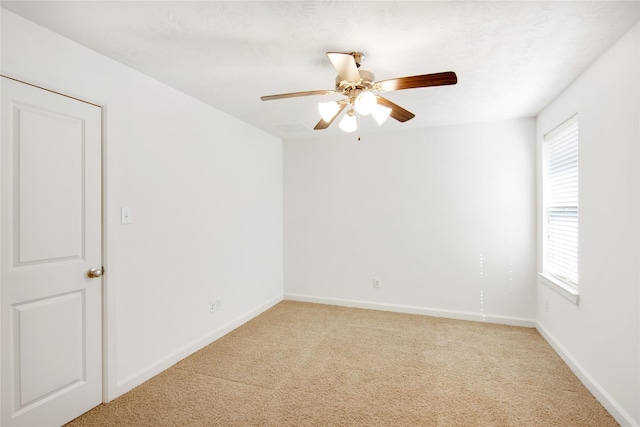 carpeted spare room featuring ceiling fan