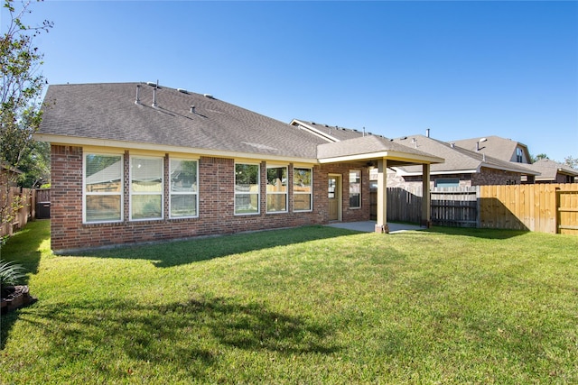 back of house with central AC unit, a lawn, and a patio