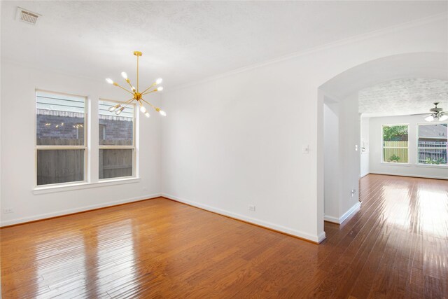 unfurnished room with wood-type flooring, ceiling fan with notable chandelier, and ornamental molding