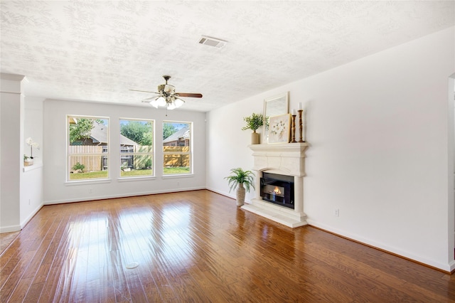 unfurnished living room with ceiling fan, a textured ceiling, and hardwood / wood-style floors