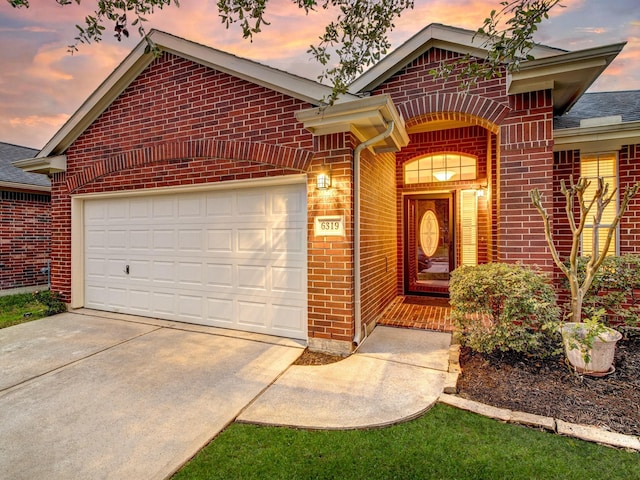 ranch-style house featuring driveway, brick siding, and an attached garage