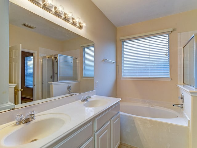 bathroom with tile patterned floors, vanity, and plus walk in shower