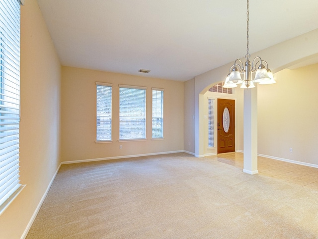 entrance foyer featuring light colored carpet and a notable chandelier