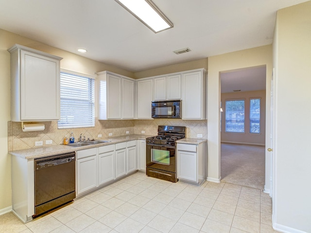 kitchen with white cabinetry, sink, tasteful backsplash, and black appliances