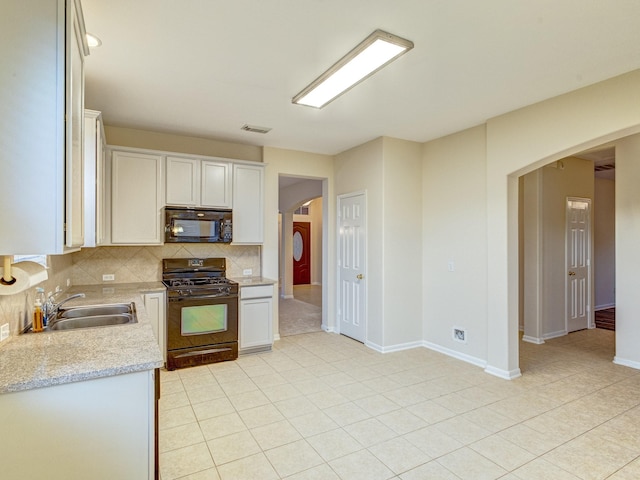 kitchen featuring tasteful backsplash, black appliances, sink, white cabinetry, and light stone counters