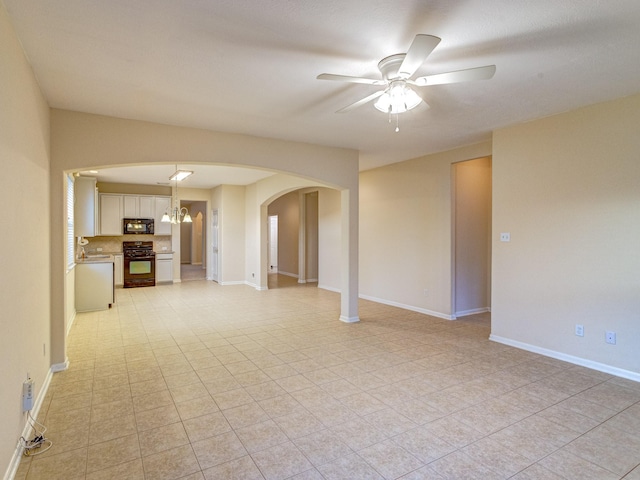 spare room featuring ceiling fan with notable chandelier and sink