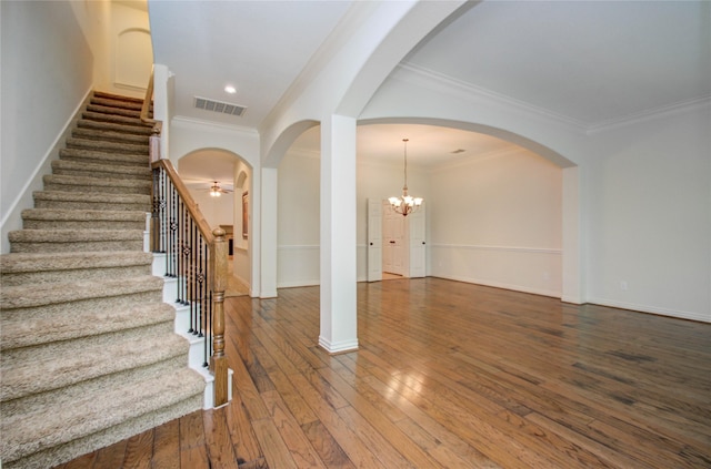 foyer entrance featuring dark hardwood / wood-style floors, ceiling fan with notable chandelier, and crown molding