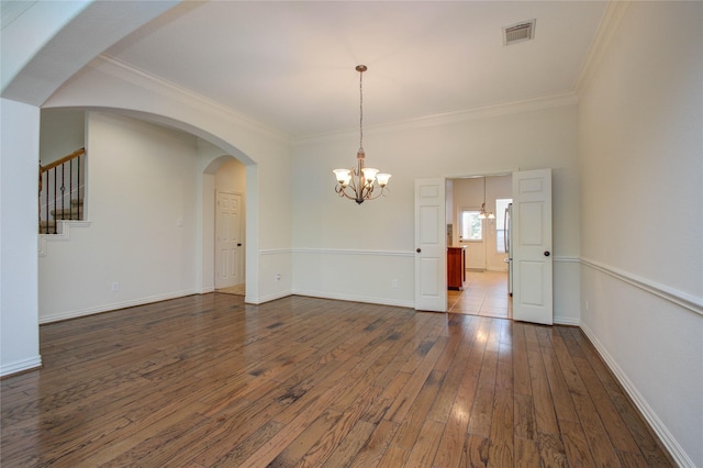 unfurnished room with dark hardwood / wood-style flooring, ornamental molding, and a chandelier