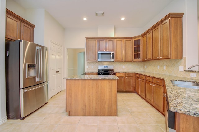 kitchen featuring light tile patterned floors, sink, appliances with stainless steel finishes, and a center island