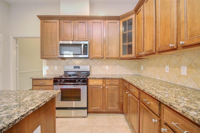 kitchen featuring light stone countertops, light tile patterned floors, and appliances with stainless steel finishes