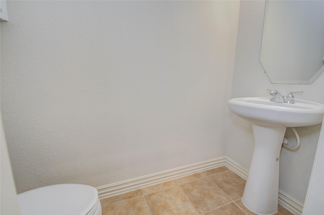 bathroom featuring toilet and tile patterned flooring