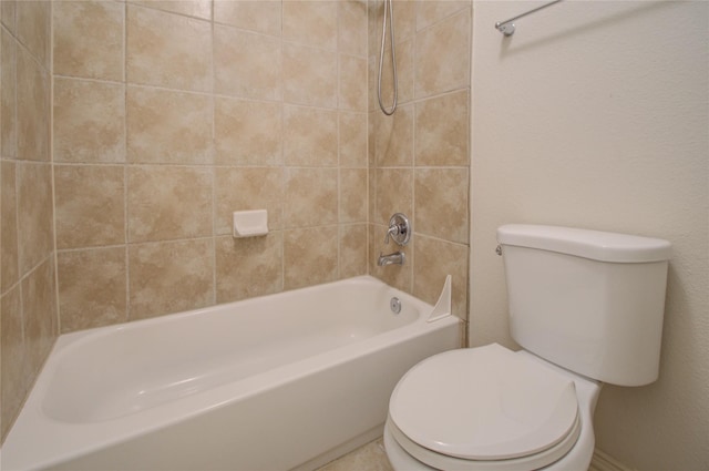 bathroom featuring toilet and tiled shower / bath