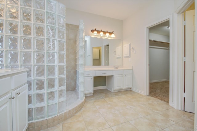 bathroom with walk in shower, vanity, and tile patterned floors