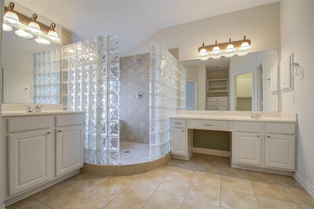 bathroom featuring a tile shower, tile patterned floors, and vanity