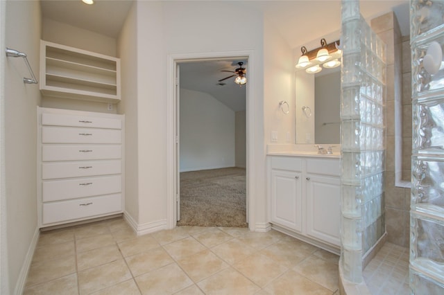 bathroom with ceiling fan, tile patterned flooring, walk in shower, and vanity