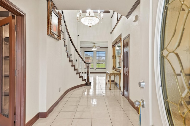 foyer entrance featuring light tile patterned flooring and ceiling fan with notable chandelier