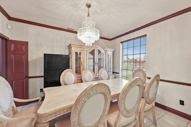 tiled dining room with a notable chandelier and crown molding